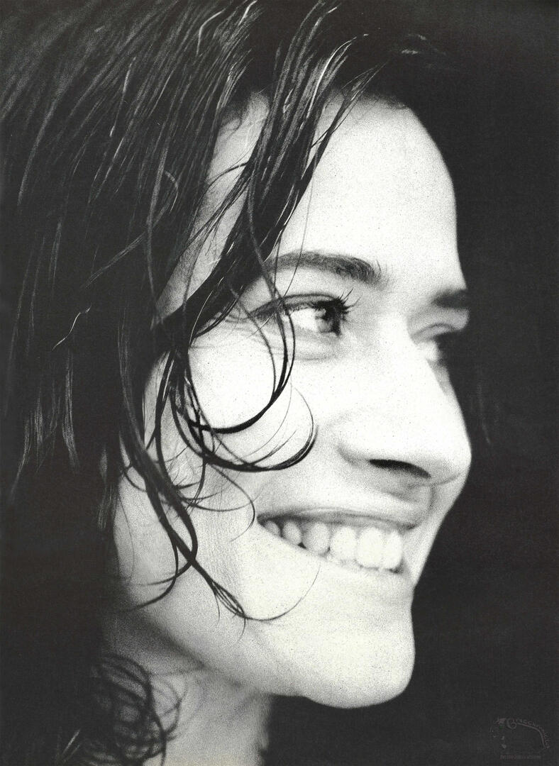 Continuation of Interview magazine spread, featuring black and white profile portrait of a smiling Lorraine Bracco with wet hair against a dark background.