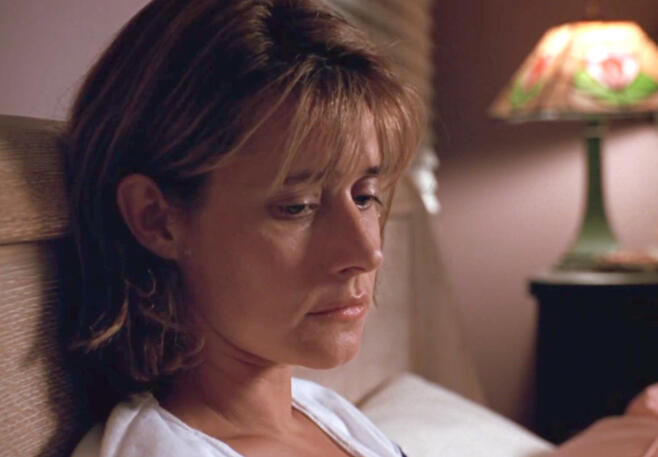 4 Lorraine Bracco as Bobbie laying in bed and looking down thoughtfully in Talent for the Game.