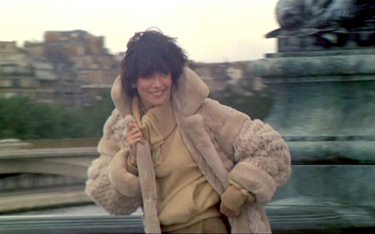 4 Lorraine Bracco smiling in a plush beige fur coat and turtleneck, playing her character Bubble in the 1979 Marc Camoletti film Duos sur canapé.
