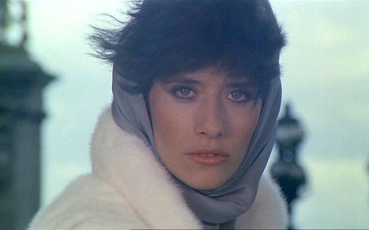 7 Close-up of Lorraine Bracco wearing a white coat and grey silk headscarf as Bubble in the 1979 French comedy movie Duos sur canapé.