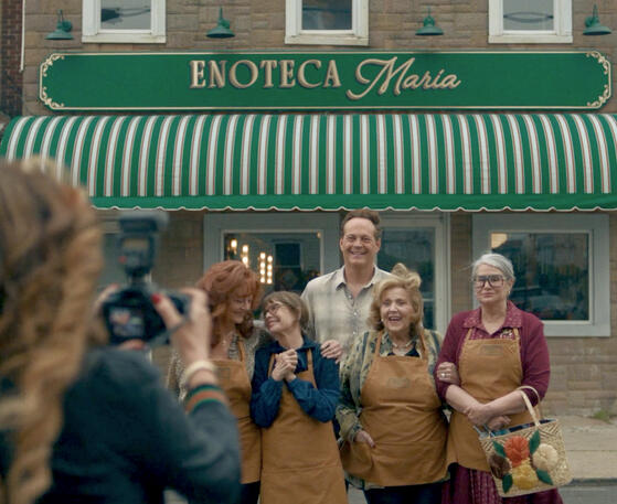 3 Cast group photo outside Enoteca Maria restaurant featuring Lorraine Bracco from the movie Nonnas.