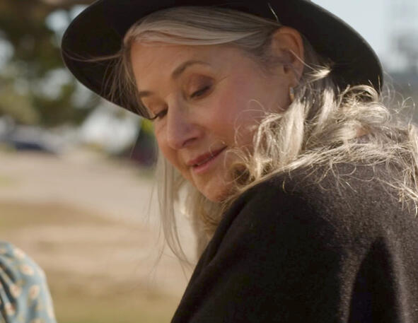 1 Lorraine Bracco smiling in a black wide-brimmed hat in Monster Summer.