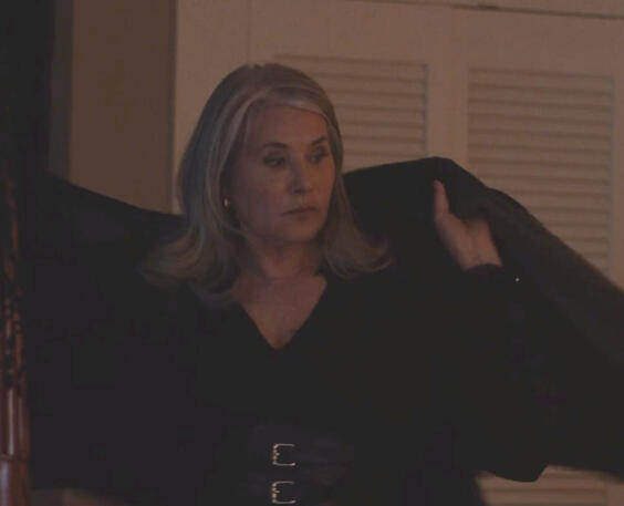 6 Lorraine Bracco holding open a black cloak with a serious face in Monster Summer.