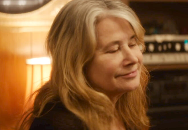 3 Lorraine Bracco looking downward in warm lighting, close-up from Jacir movie.