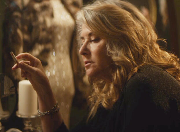 2 Lorraine Bracco holding a cigarette indoors in Jacir film.
