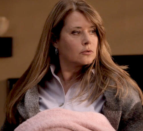 9 Lorraine Bracco as Angela Rizzoli looking to the side in a cosy shawl.