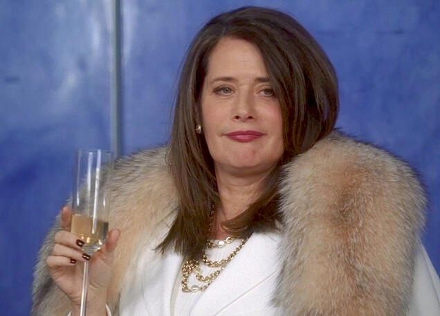 janice Lorraine Bracco holding champagne looking smug in a fur collar coat on Lipstick Jungle.