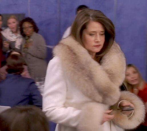 lasher Lorraine Bracco wearing a white coat with fur trim on Lipstick Jungle.