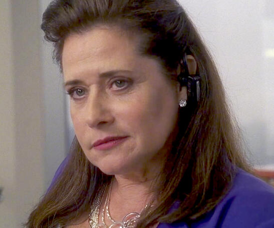 underrated Lorraine Bracco wearing a bluetooth headset and blue blazer and looking smug on Lipstick Jungle.