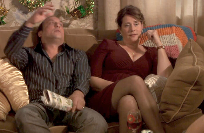 6 Lorraine Bracco sitting on a sofa next to family looking concerned in a scene from Snowglobe.