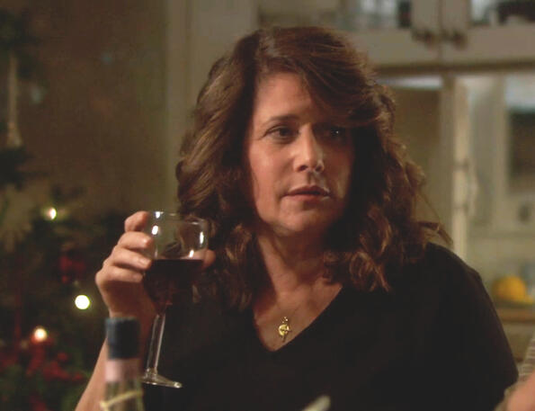 8 Lorraine Bracco holding a wine glass during a holiday party scene in the film Snowglobe.