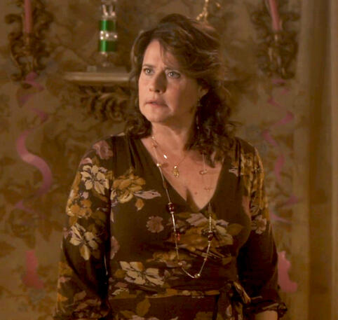 11 Lorraine Bracco in a floral dress looking angry in a scene from the holiday movie Snowglobe.