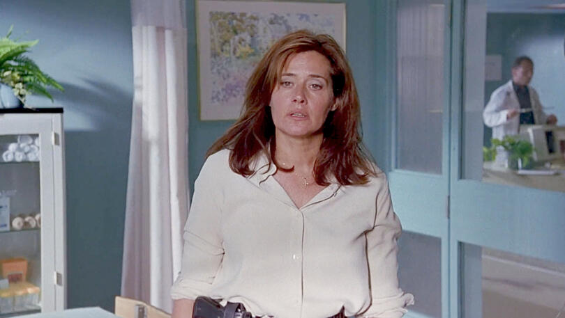 12 Lorraine Bracco standing in a hospital visiting room looking exhausted in movie Tangled.