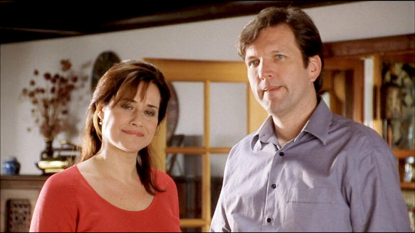 3 Lorraine Bracco and a male co-star Martin Donovan standing together indoors in Custody of the Heart film.