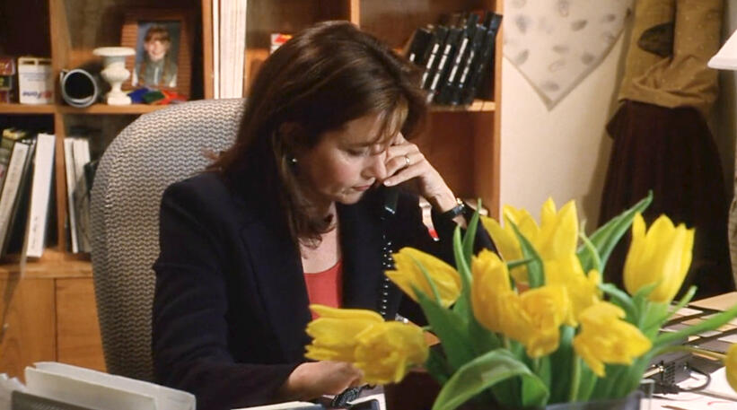 5 Lorraine Bracco talking on an office phone behind a bouquet of yellow tulips in Custody of the Heart.