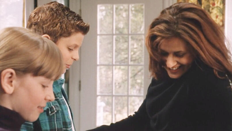 10 Lorraine Bracco smiling happily with a young Michael Cera and Charlotte Arnold in a scene from Custody of the Heart.