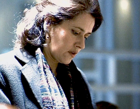 12 Lorraine Bracco looking down thoughtfully in coat and scarf in The Taking of Pelham 1 2 3.
