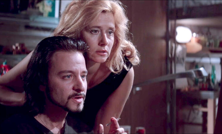 1 Lorraine Bracco looking over Fisher Stevens' shoulder at a computer screen in the movie Hackers.