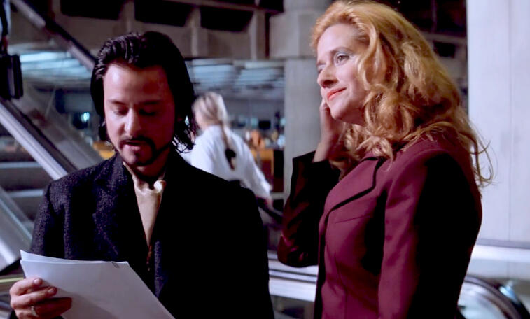 3 Lorraine Bracco smiling next to Fisher Stevens looking down in a scene from the movie Hackers.