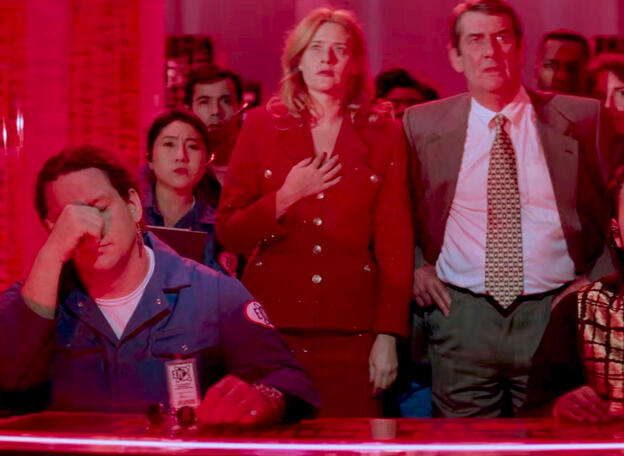 9 Lorraine Bracco in a red suit standing among a crowd looking shocked in Hackers.