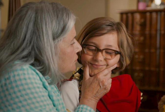 5 Lorraine Bracco gently squeezing her grandson's chin in The Mother, the Menacer, and Me.