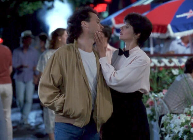 8 Lorraine Bracco holding Michael Keaton's face in a scene from The Dream Team.