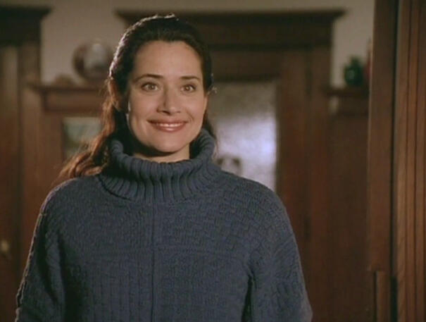 3 Lorraine Bracco smiling while wearing a navy grey turtleneck sweater in a scene from Getting Gotti.