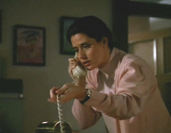 5 Lorraine Bracco holding a white telephone receiver and cable in Getting Gotti movie scene.