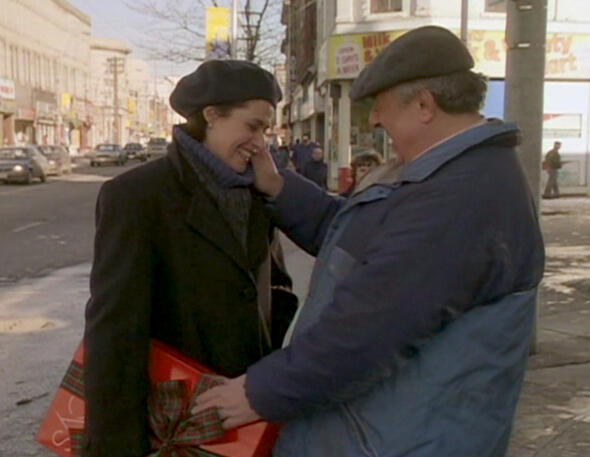 10 An older man smiling and touching Lorraine Bracco's face on a New York city street in a Getting Gotti scene.