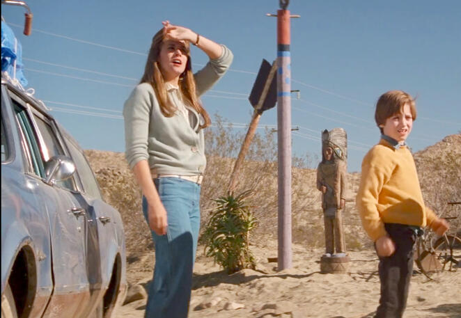 9 Lorraine Bracco shielding her eyes from the sun in a desert landscape, standing next to Elijah Wood and a car in Radio Flyer.
