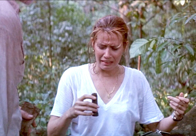 10 Lorraine Bracco holding a container with a disgusted expression in Medicine Man film.