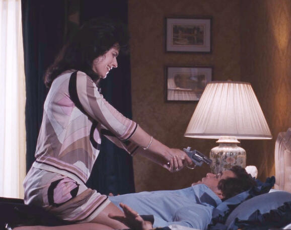 1 Lorraine Bracco pointing a gun at Ray Liotta in a bedroom scene from Goodfellas movie.