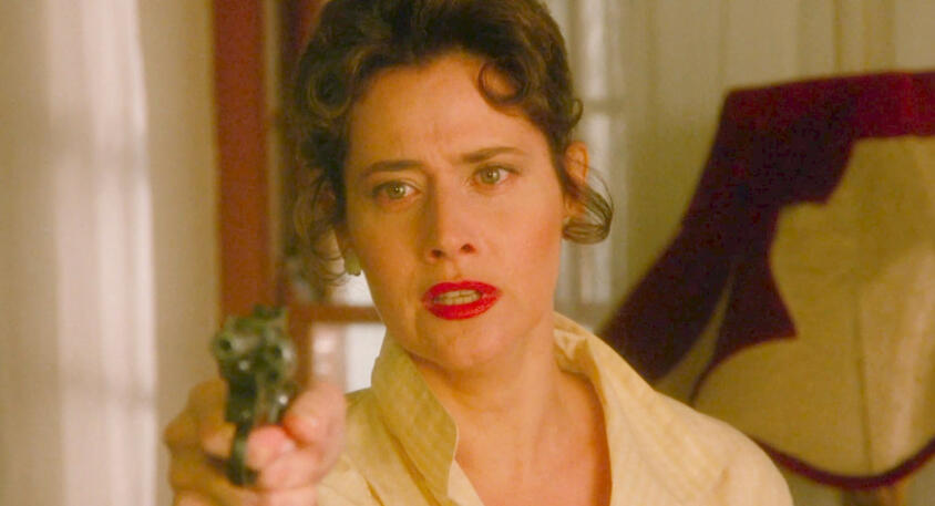 5 Lorraine Bracco pointing a gun with red lipstick in Les Menteurs