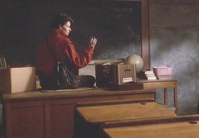 7 A character sitting on a desk looking at a snow globe in the 1989 movie Sing.