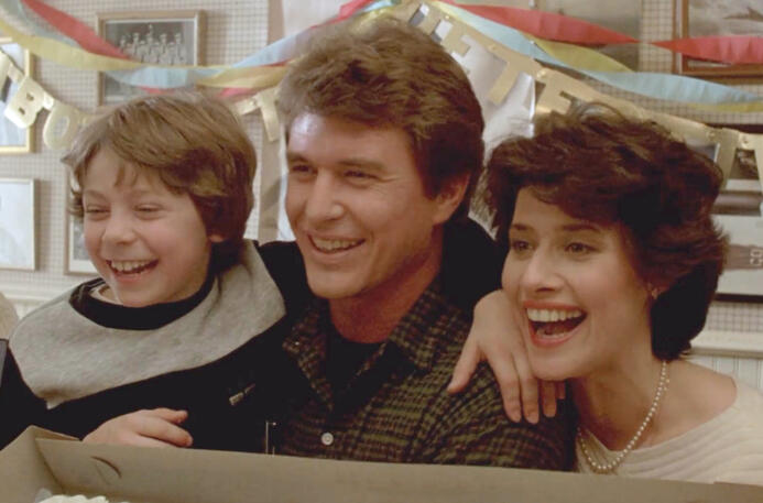 6 Lorraine Bracco smiling alongside Tom Berenger and a child in Someone to Watch Over Me.