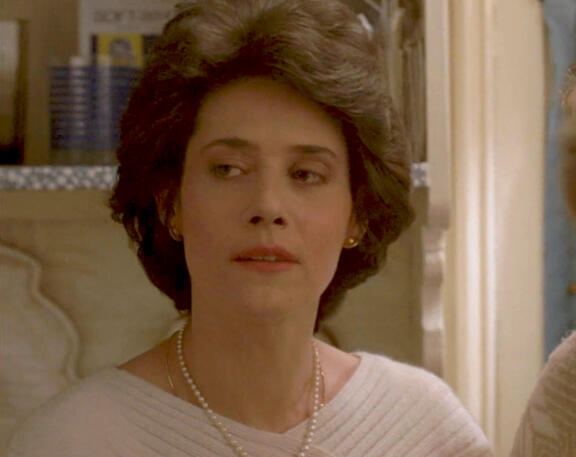 7 Close-up of Lorraine Bracco in a white top and pearl necklace in Someone to Watch Over Me.