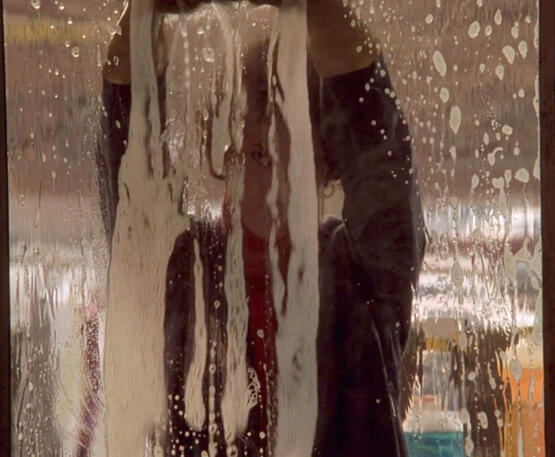 11 Lorraine Bracco seen through a soapy, washed glass window in Someone to Watch Over Me.