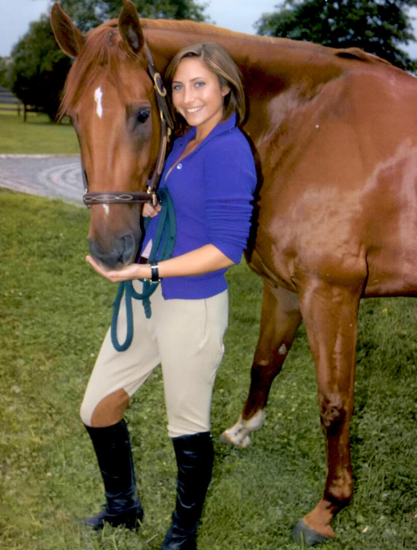 Stella Keitel, daughter of actress Lorraine Bracco, smiling alongside a chestnut horse for the HamptonStyle magazine lifestyle feature.