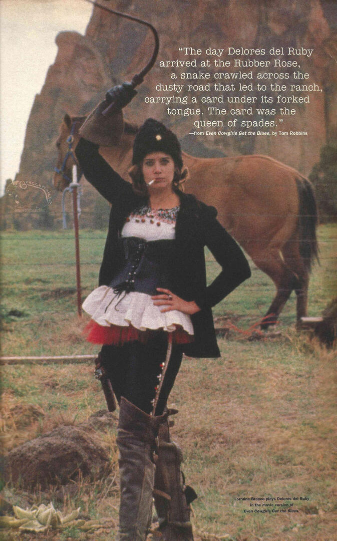 Interview magazine spread featuring Lorraine Bracco as Delores del Ruby in Even Cowgirls Get the Blues. She poses in western attire holding a whip with a horse and desert rocks behind her. Includes a quote from Tom Robbins' novel.